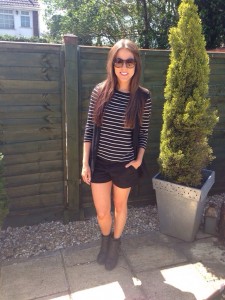 A picture of a girl wearing Zara black shorts, a Zara stripe top, a Zara waistcoat and Kurt Geiger boots