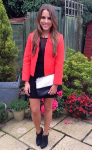 A picture of a girl wearing a Topshop black dress and orange jacket