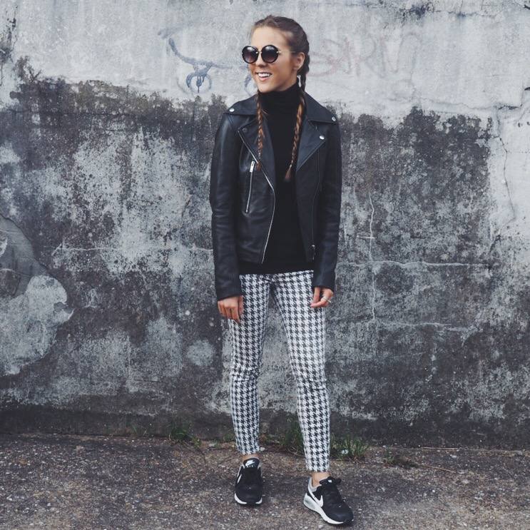  A picture of a girl wearing Zara dogtooth trousers, Zara roll neck sweater, Zara leather jacket, Nike trainers and braids.
